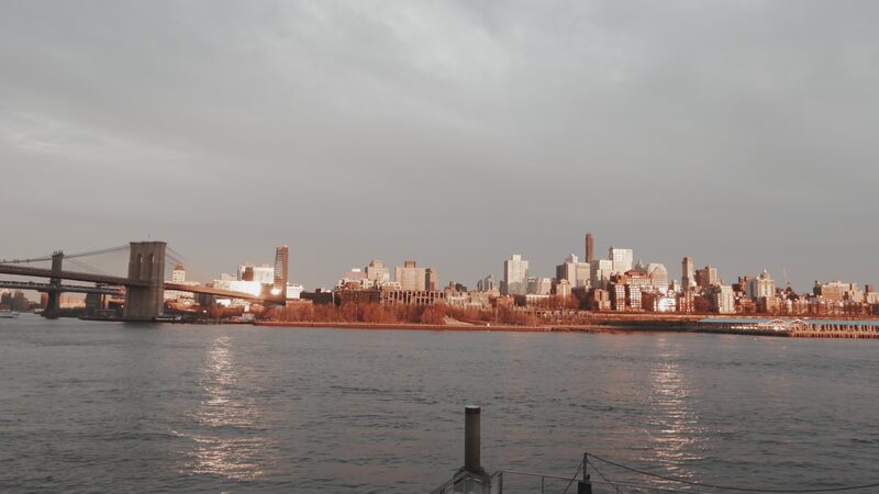 Brooklyn Bridge and the Manhattan skyline in warm evening light.