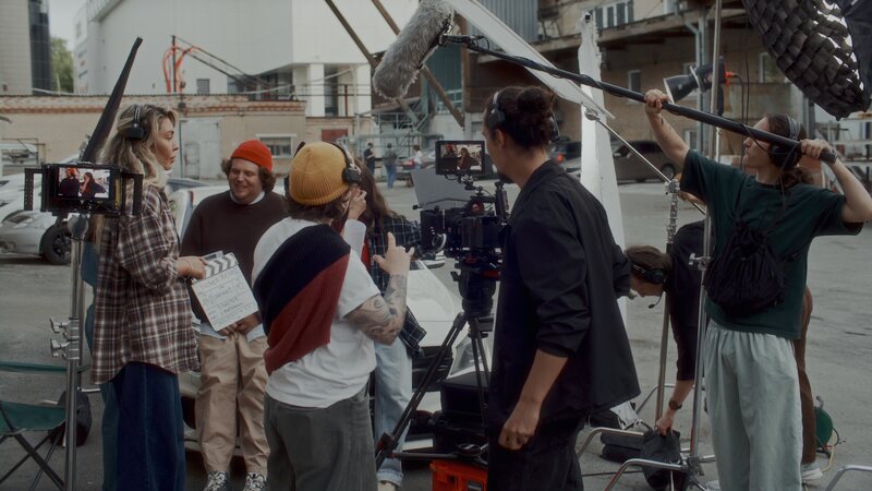Cinema camera, boom operator and crew on an exterior production set.
