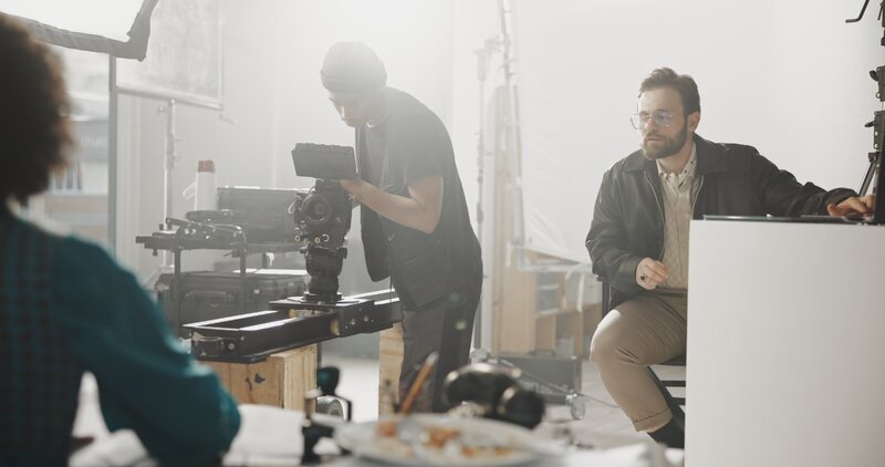 Camera crew preparing a shot on a warmly lit film set.